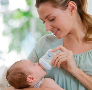Мама храни новородено бебе от бутилка