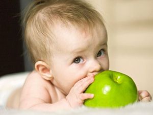 Хлапето се опитва да дъвче на ябълка