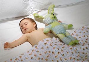 Дете на 10 месеца спи в детско креватче с любима играчка