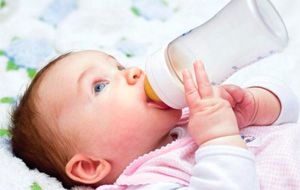 Бебето пие мляко от бутилката