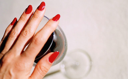 Ръката с яркочервени нокти покрива чашата, защото едно интелигентно момиче вече не иска вино