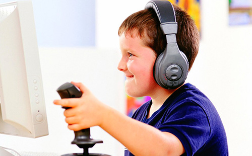 Момче със слушалки играе компютърна игра