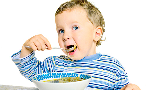 Едно момче яде супа с лъжица