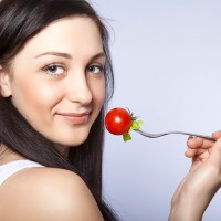 Една жена яде домат
