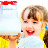 Момичето държи кана с мляко