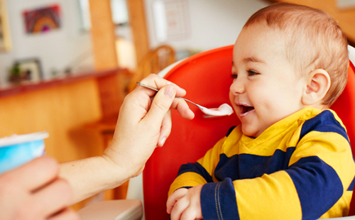 Радостното бебе яде с лъжица биокефир