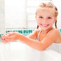 Весело момиче с пигтейли измива ръцете си