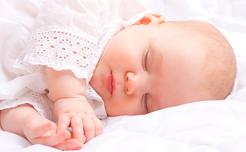 Невинен сън на бебе в бяла дантела