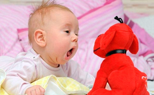 Деца с отворена уста се вглеждат в играчка с червен цвят
