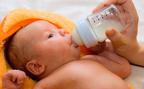 Новороденото пие мляко от бутилка