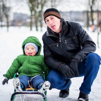Бащата и бебето показват езика през зимата