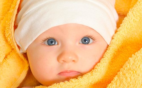 Бебе в шапка и жълта кърпа