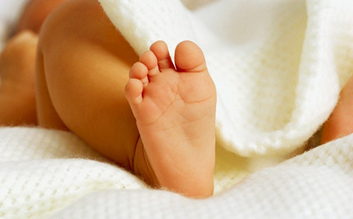Бебешки крак, който се взираше от одеялото