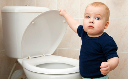 Мръсно момче в синя тениска затваря капака на тоалетната