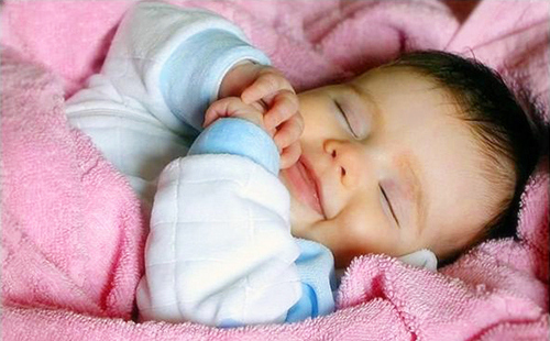 Бебето спи на сладък сън и дори се усмихва