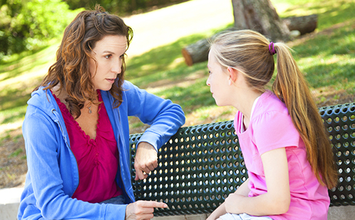 Мама и дъщеря имат сериозен разговор в парка