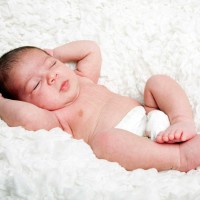 Детето спи с пълно удоволствие на бяло одеяло