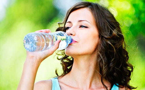 Млада жена пие чиста вода