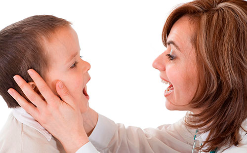 Докторът изследва гърлото на детето