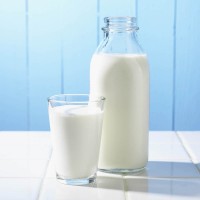Бутилка и чаша мляко на масата