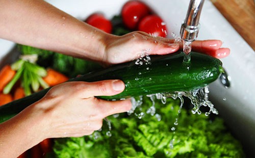 Ръцете измиват краставицата