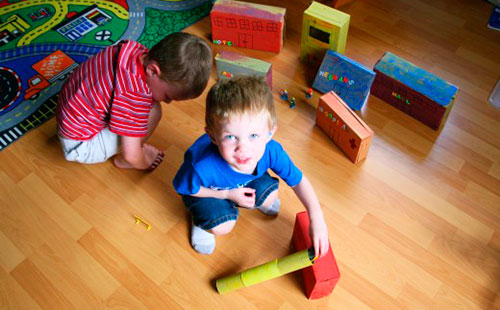 Две момчета, които играят на пода