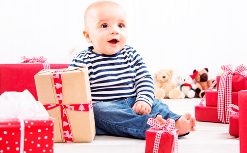 Бебета седи близо до кутии за подаръци