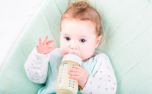 Малко дете пие млечна смес от бутилка