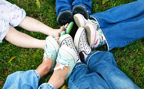 Различни обувки на краката на различни деца