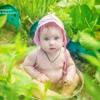 Бебе в розова панама седи в басейн