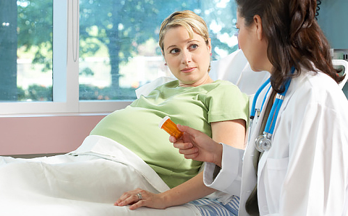 Бременна близначка слуша внимателно доктора