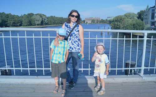 Майка и две момчета стоят на моста