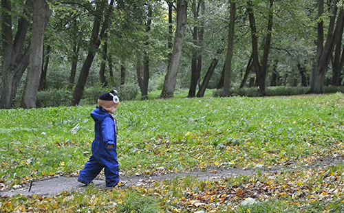 Детето се разхожда по пътеките на стария парк