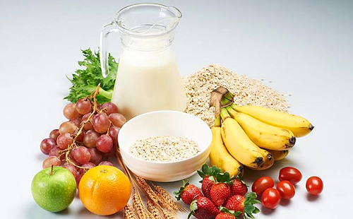 Зърнени храни, пресни плодове и кана с хладно мляко