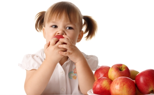 Момиче с опашки яде ябълка