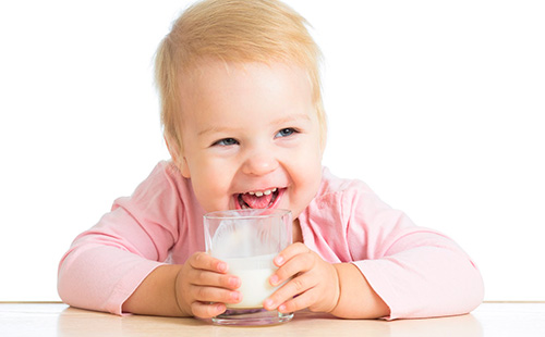 Детето пие кисело мляко от чаша