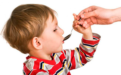 Едно момче пие лекарство от лъжица