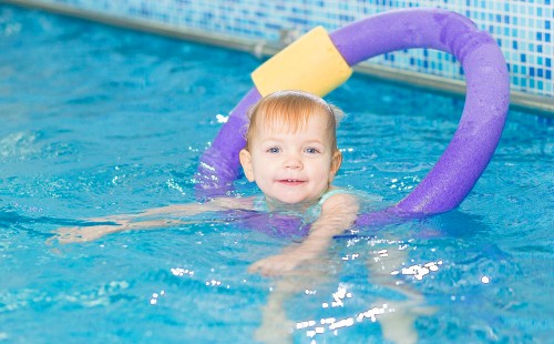 Едно щастливо дете плува в лавандула надуваем кръг